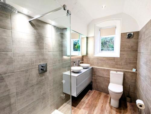 a bathroom with a toilet and a sink at 2 Bedroom Unique Converted Constabulary in Nantwich