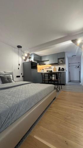 a bedroom with a large bed and a kitchen at Vamesu Frontiers - Luxury borders in Sibiu