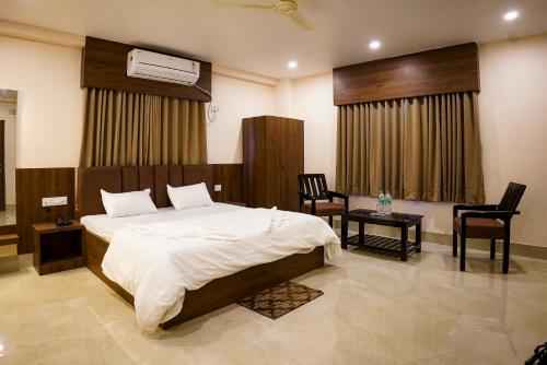 a bedroom with a bed and a table and chairs at Hotel Sagar Sonnet in Haldia