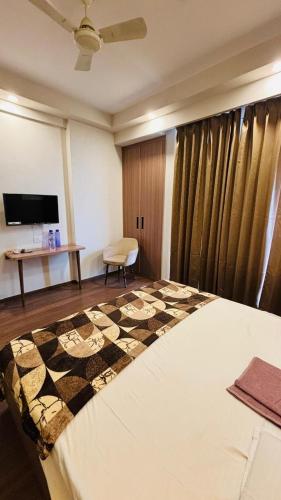 a bedroom with a bed and a table and a chair at Skybloom stays in Greater Noida