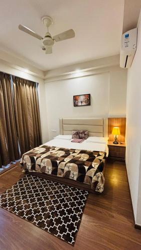 a bedroom with a bed and a ceiling fan at Skybloom stays in Greater Noida