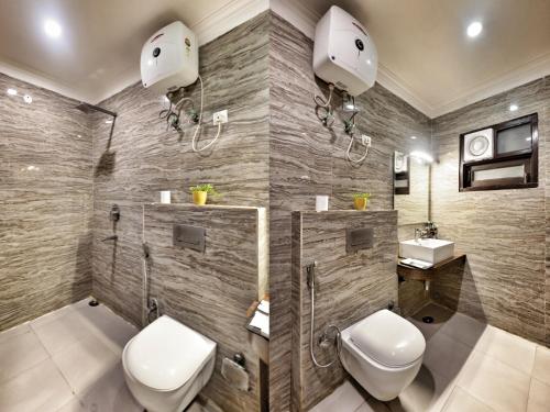 a bathroom with a toilet and a sink at Hotel Aerocity Purple Orchid in New Delhi