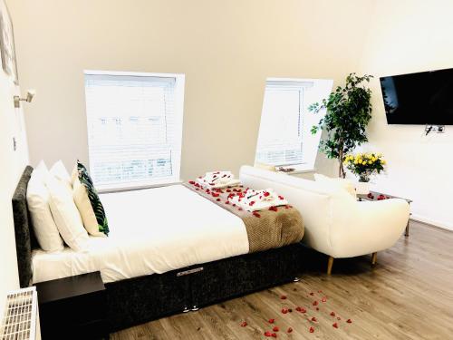 a bedroom with a white bed and a chair at Fox House, Studio Apartments in Plymouth
