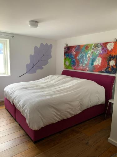a bedroom with a bed and a painting on the wall at Luxury guesthouse - Eik bij de dijk in Aalst