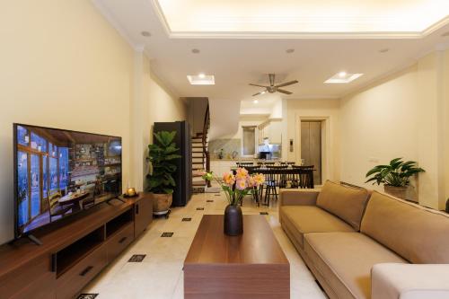 a living room with a couch and a flat screen tv at Beloved Summer House in Hanoi