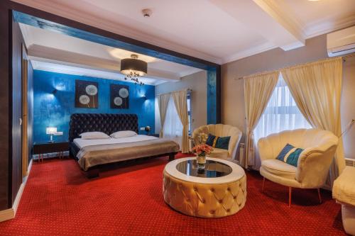 a bedroom with a bed and a table and chairs at Hotel City Break in Galaţi