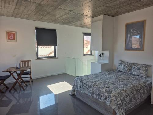 a bedroom with a bed and a table and chairs at 123 Muda Life in Sesimbra