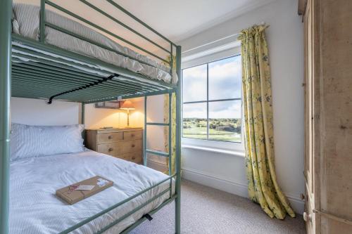 a bedroom with two bunk beds and a window at Hatchet Pond Cottage in Beaulieu