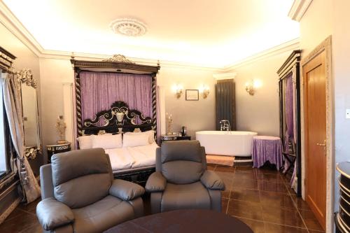 a bedroom with a tub and a bed and chairs at Ferndale Luxury Boutique Bed & Breakfast in Keel