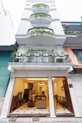 a building with a balcony with a table and chairs at Beloved Summer House in Hanoi