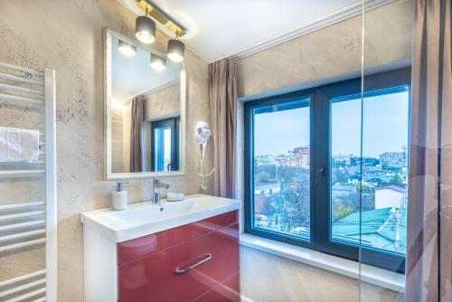 a bathroom with a sink and a large window at Hotel City Break in Galaţi