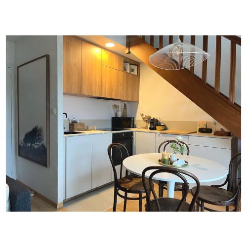 a kitchen and dining room with a table and chairs at Entre Mer et Dunes de Pin in Neufchâtel-Hardelot