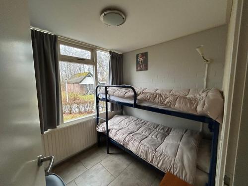 a room with two bunk beds and a window at Huisje 118 bungalowpark Simpelveld in Simpelveld