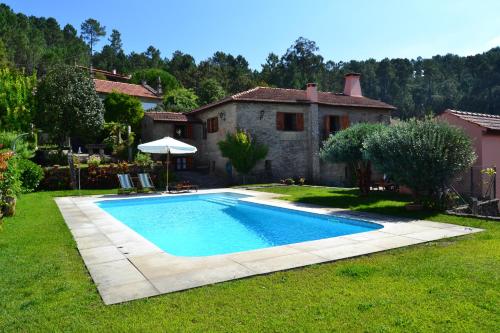 a swimming pool in the yard of a house at Casa de Fujacos in Valença