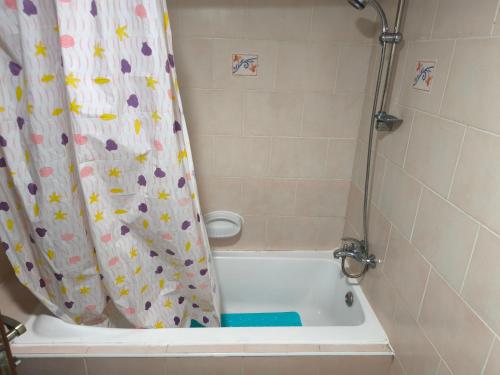 a shower curtain with flowers on it in a bathroom at Smart Home Vacation Home- AYLA in Sharjah