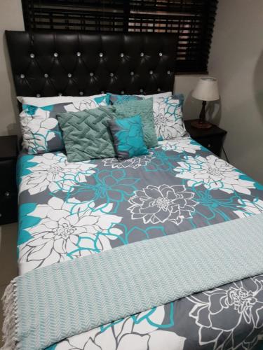a bed with blue and white sheets and pillows at Cabanas 21 in Kingsborough