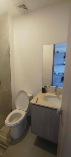 a bathroom with a toilet and a sink and a mirror at Santa marina in Santa Marta