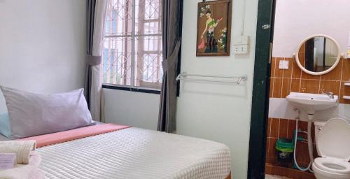 a small bedroom with a bed and a sink at Wayside Guesthouse in Chiang Mai