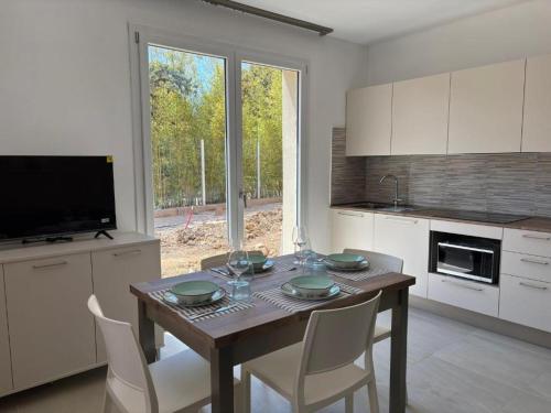 a kitchen with a table with chairs and a television at Acquaviva Suite in San Vincenzo
