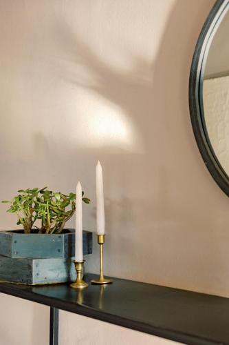 two candles on a table next to a mirror at The Garden Home in Arusha