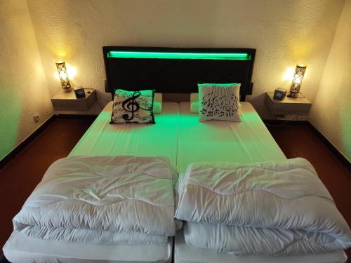 une chambre avec un lit avec deux oreillers dessus dans l'établissement Le Tau, à Saintes-Maries-de-la-Mer