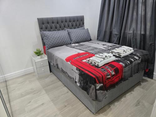 a bedroom with a bed with a red suitcase on it at Luxury One Bedroom En-suite with Free Parking in Harrow Weald