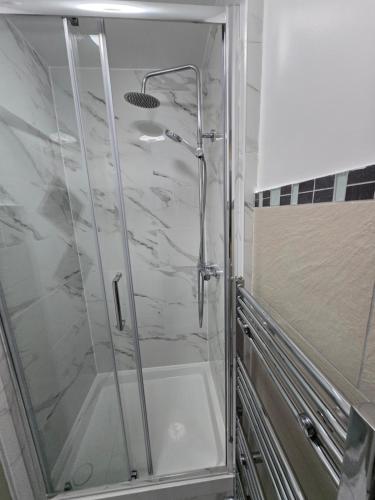 a shower with a glass door in a bathroom at Luxury One Bedroom En-suite with Free Parking in Harrow Weald