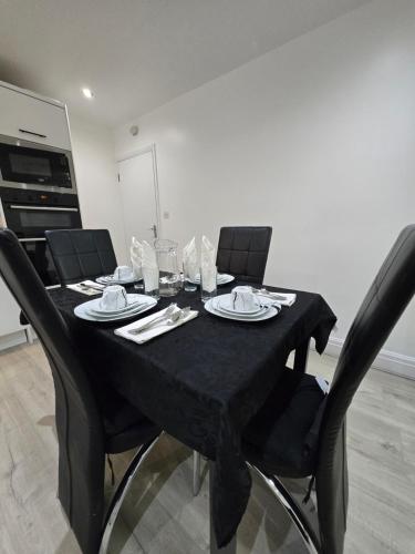 a dining room table with chairs and a black table cloth at Luxury One Bedroom En-suite with Free Parking in Harrow Weald