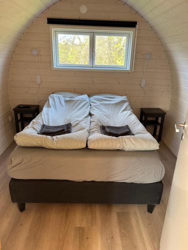 a bed in a room with a window at Hotel Osted in Lejre