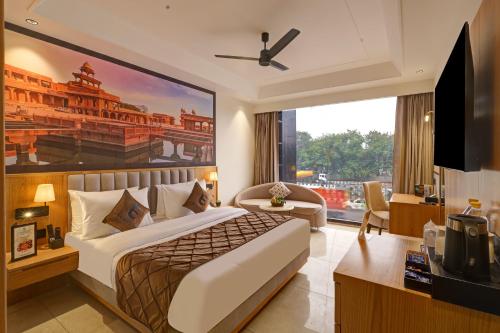 a hotel room with a bed and a large window at Airport Premier In With Free Airport Drop in New Delhi