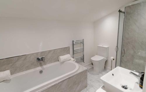 a bathroom with a tub and a toilet and a sink at Adderley House B&B in Pitlochry