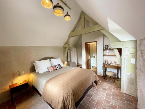 a bedroom with a large bed and a desk at La source de Vaugadeland in Nazelles