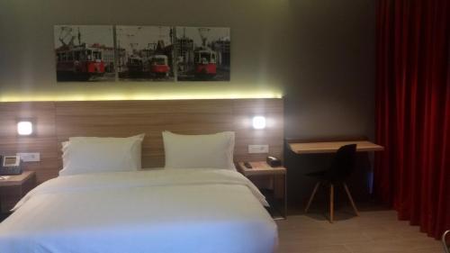 a bedroom with a large white bed and a desk at Caramel Boutique Hotel in Beirut