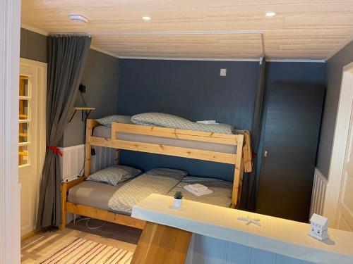 two bunk beds in a room with a desk at House under the Aurora Cozy Private Home with Fireplace in Laukvik
