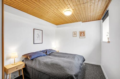 a bedroom with a bed and a wooden ceiling at Fewo Vidstrup Hygge in Vidstrup