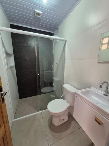 a bathroom with a toilet and a shower and a sink at El Tata in Arroio do Silva