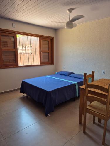 a bedroom with a bed and a chair and a table at El Tata in Arroio do Silva