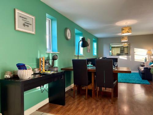 a living room with a dining room table with chairs at The Orchid-Central Beeston-Private Apartment-SmartTV-Free Wi-Fi-Tram-Parking in Nottingham