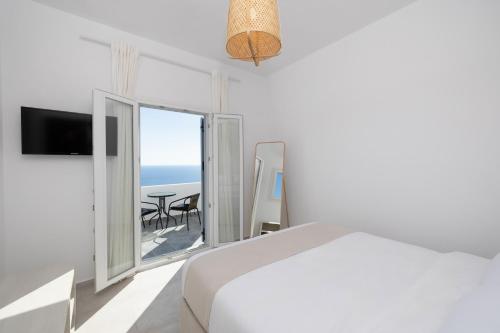 a bedroom with a bed and a view of the ocean at Occhio-Nero Cycladic Private Villa with Pool & Sunset View Jacuzzi in Akrotiri
