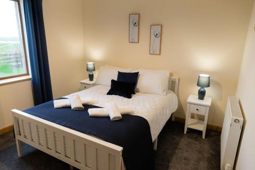 a bedroom with a bed with towels on it at Taftnica in Burray Village