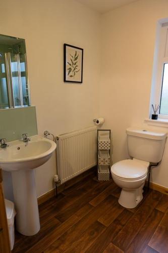 a bathroom with a white toilet and a sink at Taftnica in Burray Village