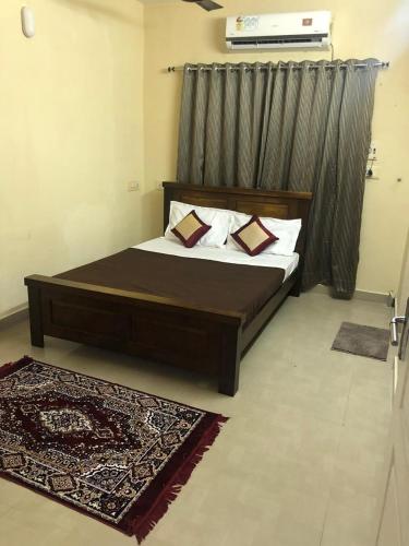 a bedroom with a large bed with a wooden headboard at Zest Homes Nugambakkam in Chennai