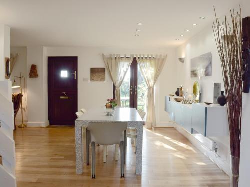 a kitchen with a table and a dining room at Alices Cottage in Stepaside