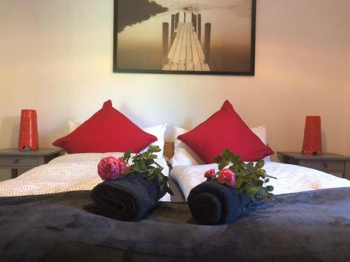 a bed with red pillows and flowers on it at Bergblick Kampenwand in Aschau im Chiemgau