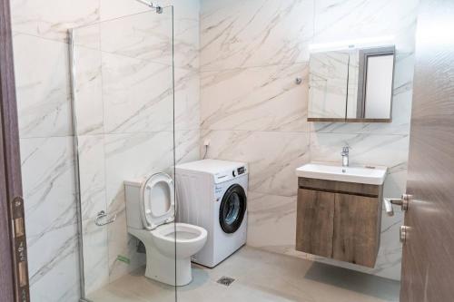a bathroom with a toilet and a washing machine at Symphony Suite in Panormos Rethymno