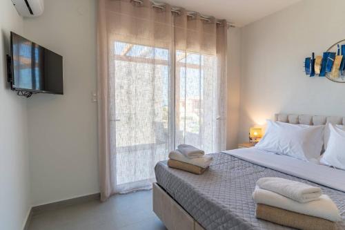a bedroom with a bed and a large window at Symphony Suite in Panormos Rethymno