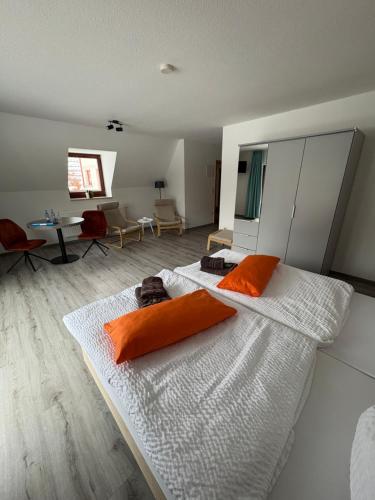 a bedroom with a large bed with orange pillows on it at An der Gärtnerei in Dömitz