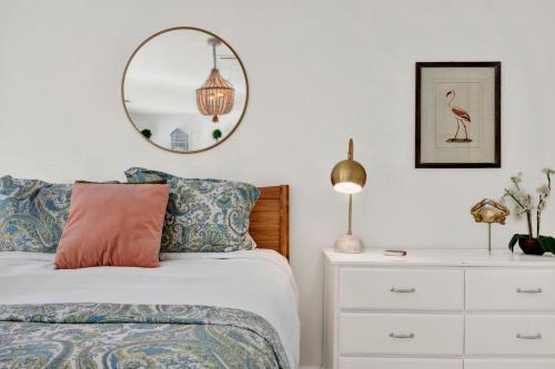 a bedroom with a bed and a mirror and a dresser at Crawford Carriage House in Savannah