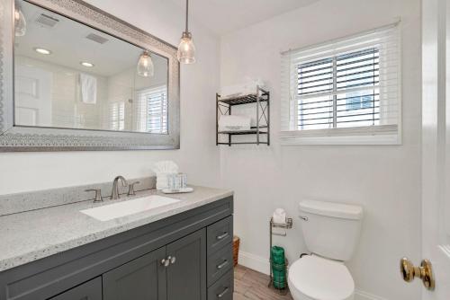 a bathroom with a sink and a mirror and a toilet at Crawford Carriage House in Savannah