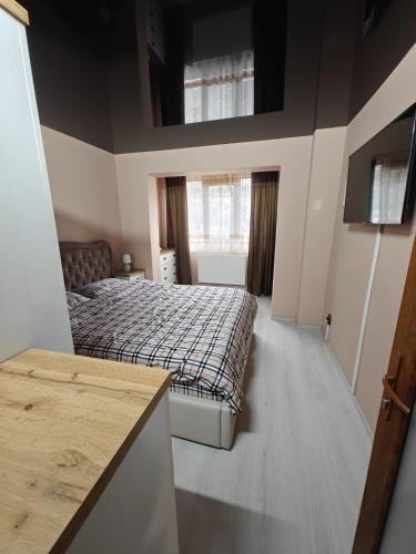 a small bedroom with a bed and a window at Sunset Home Apartment in Galaţi